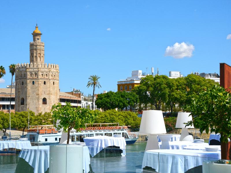 Imagen de la torre del oro desde la terraza de un restaurante en Sevilla.